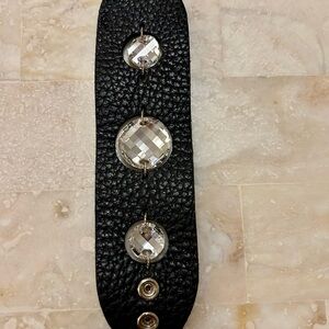 Cuff bracelet made of leather and shiny faceted rhinestones.